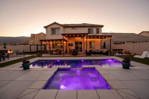 Backyard Swimming pool with a hot tub at night