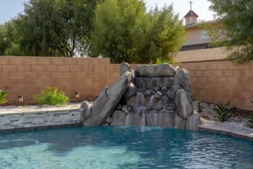 Backyard pool with a stone waterfall