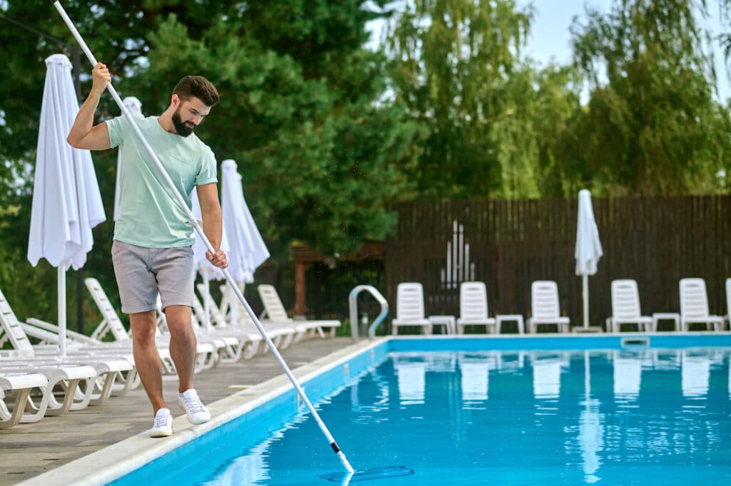 person cleaning pool to ensure good pool care