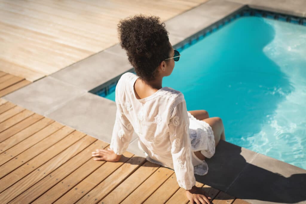 woman sitting beside a small backyard pool