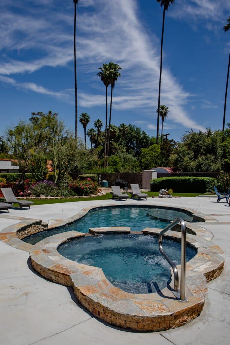 Custom backyard pool with a hot tub